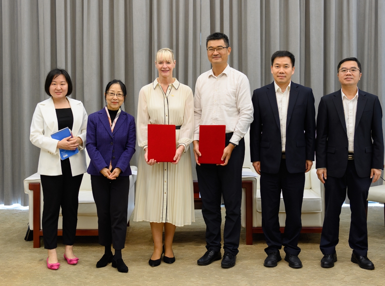 A photo showing representatives of the World Energy Council and China Southern Power Grid presenting a folder at a formal signing event.
